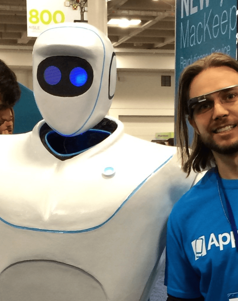 Brian Messenlehner in an AppPresser WordPress shirt and Google Glass next to a white robot at a tech expo