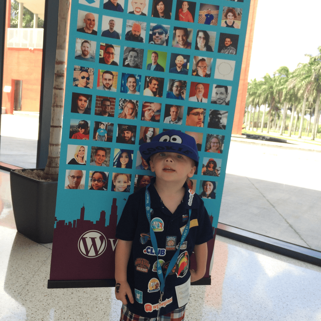 My young son in a Cookie Monster hat and a shirt covered in WordPress stickers at WordCamp Miami