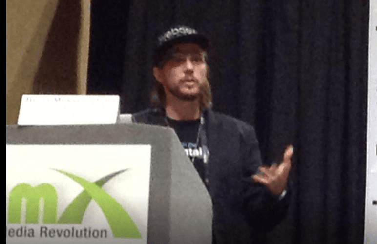 Brian Messenlehner speaking at a podium at a media technology conference