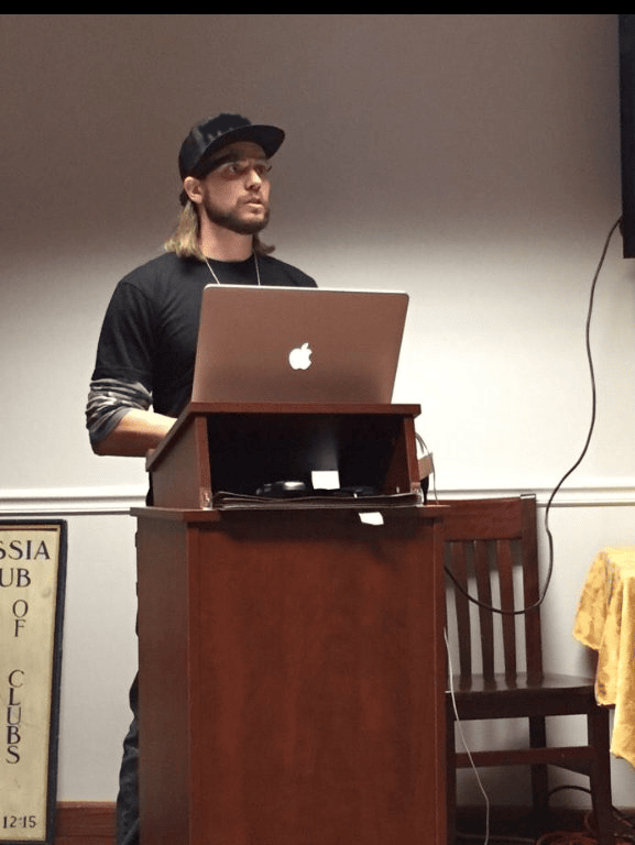 Brian Messenlehner speaking at a podium with a laptop during a WordPress talk