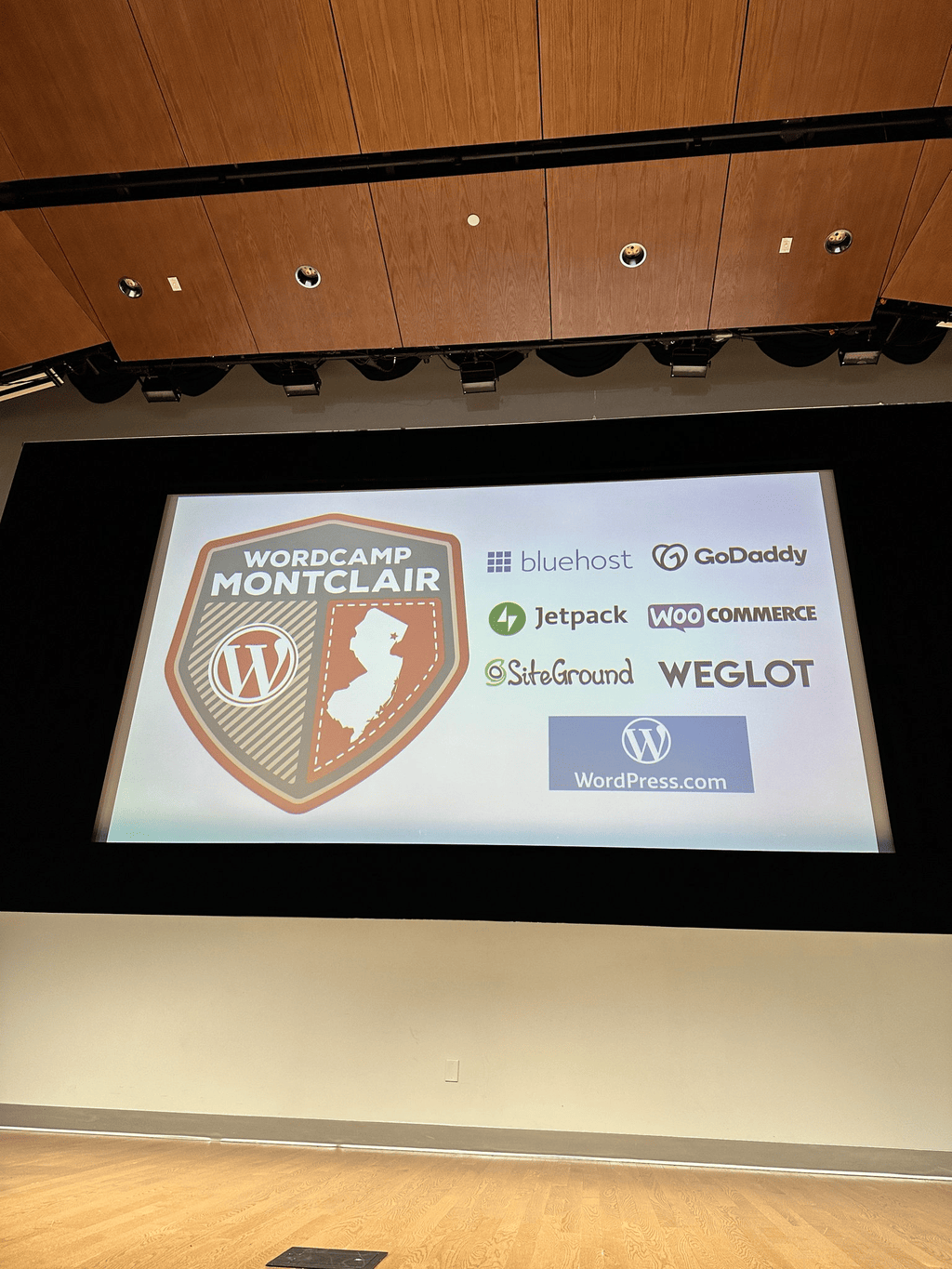 WordCamp Montclair logo and sponsor slide on the main stage screen