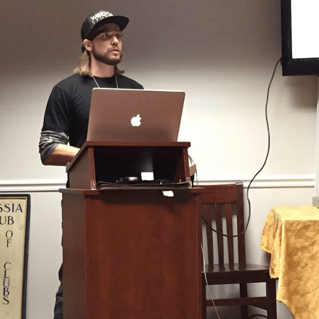 Brian presenting at a podium with a laptop at a WordPress meetup